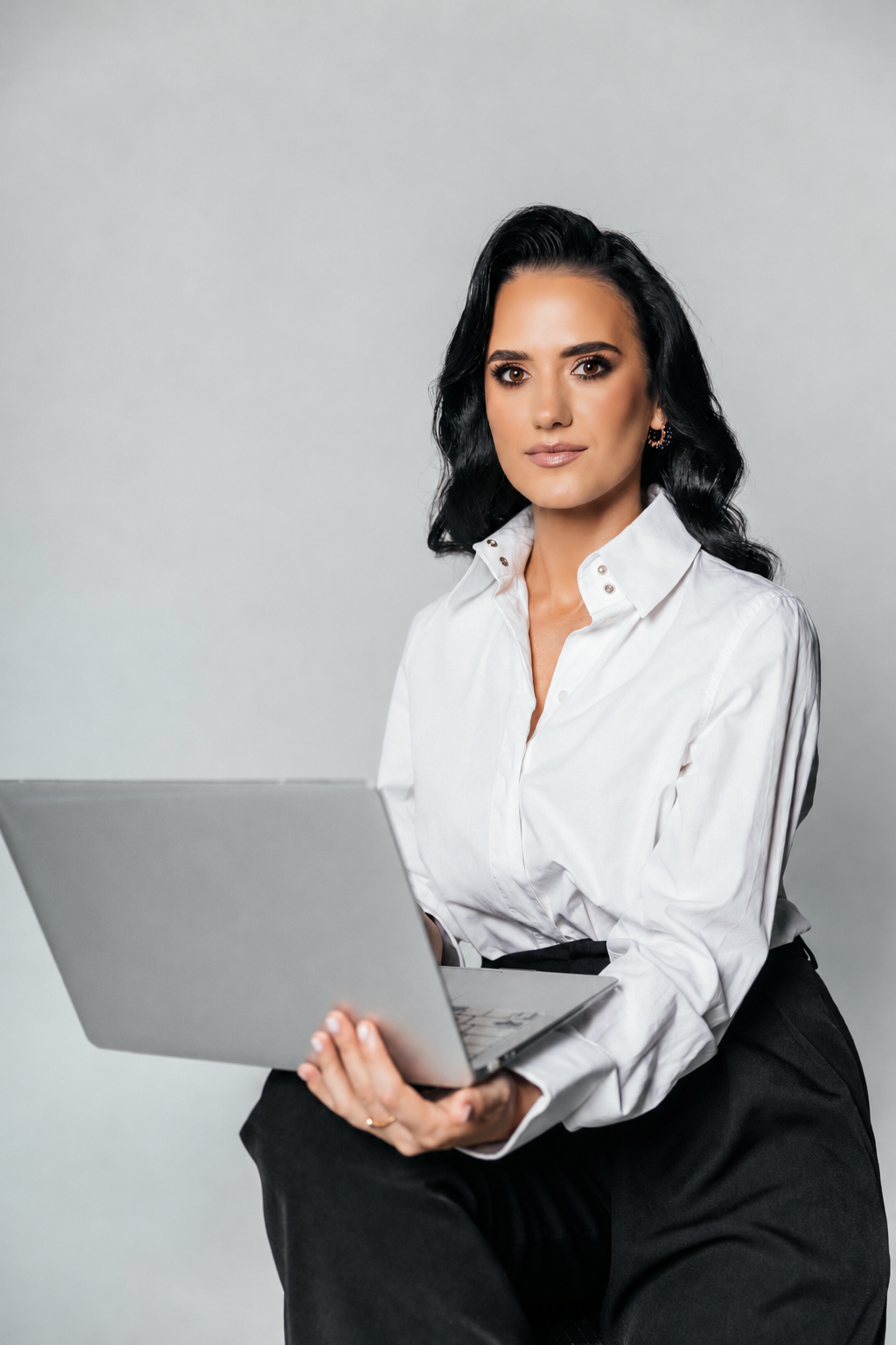 Svitlana Zubchyk, Founder and Director of NextGen AccountingPro, seated with a laptop